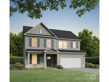 Charming two-story home with gray siding, white trim, shutters, well-manicured lawn and a two-car garage at 5120 Izzo Ln, Charlotte, NC 28214