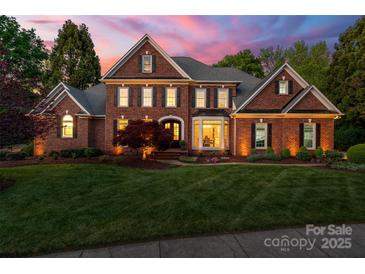Elegant brick home with a manicured lawn and beautiful landscaping, exuding curb appeal at 5809 Woodleigh Oaks Dr, Charlotte, NC 28226