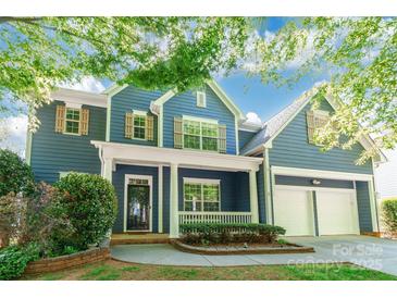 Charming two-story blue home with a welcoming front porch and an attached two-car garage at 8428 Westmoreland Lake Dr, Cornelius, NC 28031