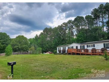 Charming single story home with a well-maintained lawn and a spacious wooden wheelchair ramp at 8813 Summerhill Dr, Waxhaw, NC 28173