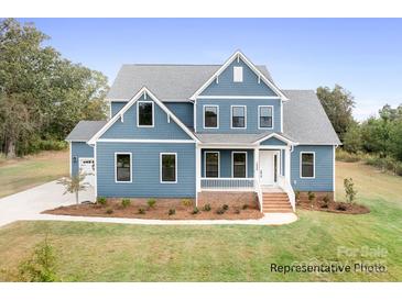 Charming two-story home with blue siding, white trim, manicured lawn and lush landscaping at 122 Huntcliff Dr, Statesville, NC 28677