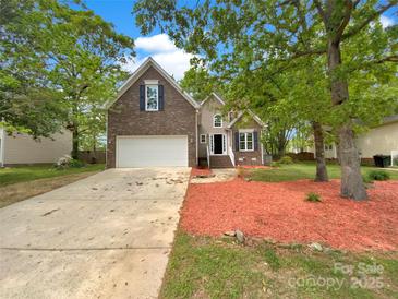 Charming two-story brick home with an attached garage and beautifully landscaped front yard at 1625 Winthrop Ln, Monroe, NC 28110
