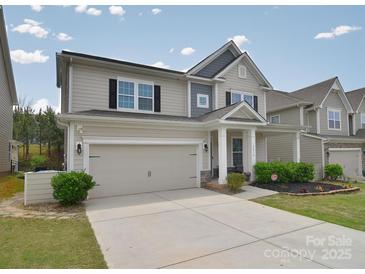 Charming two-story home featuring a neutral color palette, attached garage, and well-manicured front yard at 2014 Burton Point Ct, Waxhaw, NC 28173