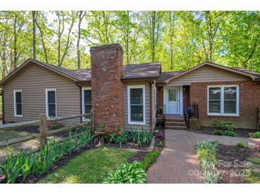 Charming home with brick chimney, fenced yard, and manicured landscaping for a welcoming curb appeal at 211 W Tennessee Ave, Bessemer City, NC 28016