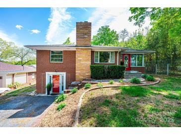 Charming brick home with a unique stacked stone chimney and well-manicured landscaping at 542 9Th Nw St, Hickory, NC 28601
