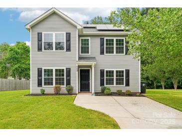 Charming two-story home with gray siding, black shutters, lush lawn, and solar panels at 759 Victory Gallop Ave, Clover, SC 29710