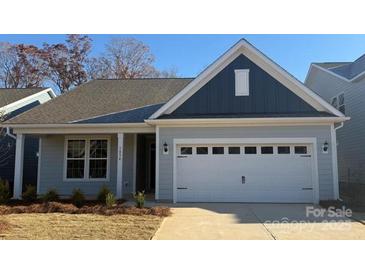 Charming one-story home features a two-car garage, lovely landscaping and craftsman details at 1034 Mapletree Ln, Indian Trail, NC 28079