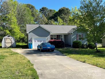 Charming single-story home with gray siding, garage, lush landscaping, and a concrete driveway at 135 Hazelwood Dr, Rockwell, NC 28138