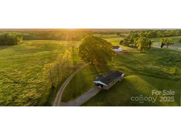 Beautiful aerial view of property showcasing the expansive green lawns and setting sun at 153 Coachman Loop, Statesville, NC 28625