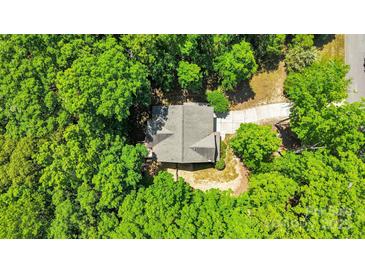 Aerial view of a home nestled among lush trees, featuring a driveway and well-maintained roof at 2417 Labelle Dr, Waxhaw, NC 28173
