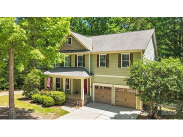 Charming two-story home with green siding, brick accents, a well-manicured yard, and an attached two-car garage at 2417 Labelle Dr, Waxhaw, NC 28173
