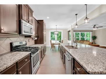 Gourmet kitchen featuring granite counters, stainless steel appliances, and hardwood floors at 2417 Labelle Dr, Waxhaw, NC 28173
