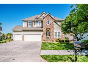 Charming two-story home with a well-maintained lawn and three-car garage, blending stone and siding details at 9860 Darby Creek Nw Ave, Concord, NC 28027