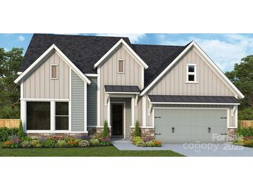 Charming home exterior with gray siding, stone accents, and a well-manicured lawn at 1019 Idyllic Ln, Waxhaw, NC 28173