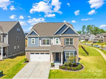 Charming two-story home with a two-car garage, brick and siding exterior, and manicured lawn at 13547 Roderick Dr, Huntersville, NC 28078