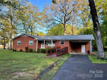 Charming single-story brick home with a ramp, covered carport and beautifully landscaped front yard at 1903 Shady Ln, Monroe, NC 28110