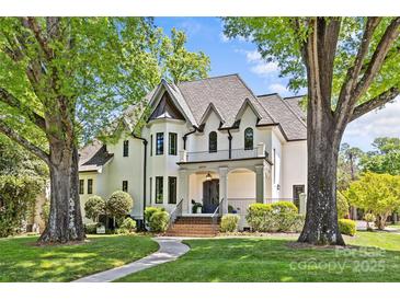 Stately white brick home featuring manicured landscaping and a welcoming entrance framed by mature trees at 2200 Hastings Dr, Charlotte, NC 28207