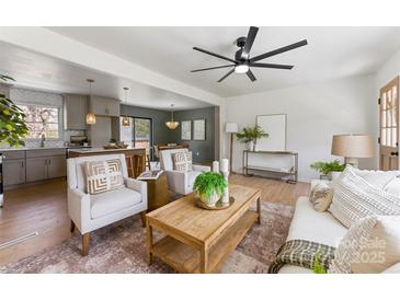 Bright living room boasts an open concept with kitchen and dining area, stylish decor, and modern ceiling fan at 2232 Glenraven Ave, Gastonia, NC 28052