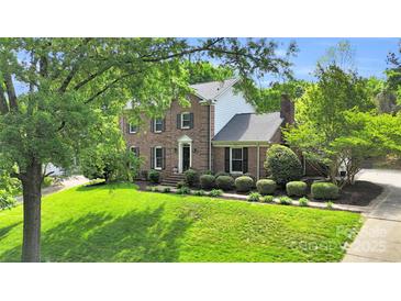 Charming two-story brick home with manicured lawn, mature trees, and classic architectural details at 2417 Hamilton Mill Rd, Charlotte, NC 28270