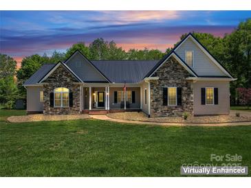 Charming exterior of home featuring stone accents, a metal roof, and a manicured lawn at 520 Steeple Chase Trl, Salisbury, NC 28144