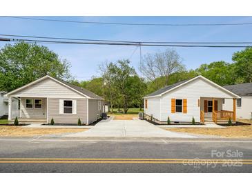 Charming matching homes feature fresh landscaping and a shared driveway at 606 & 608 Hampton Rd, Lancaster, SC 29720