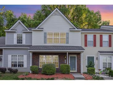 Charming two-story townhome with brick accents, neutral siding, and manicured landscaping at 7607 Petrea Ln, Charlotte, NC 28227