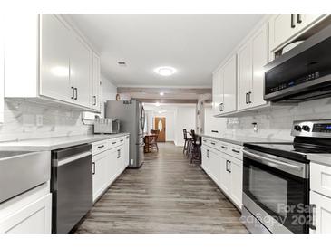Bright kitchen with stainless appliances, white cabinets, and wood floors offers a modern design at 814 Columbia Dr, Chester, SC 29706