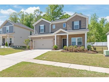 Charming two-story brick home with a well-manicured lawn and a two-car garage, perfect for Gathering living at 1020 Clementine Rd, Monroe, NC 28110