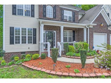 Charming brick-accented home with a cozy front porch and manicured landscaping at 10836 Maryanna Ct, Charlotte, NC 28213