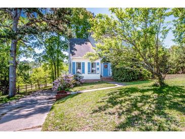 Charming home featuring blue shutters, a welcoming entrance, and mature trees on a spacious lot at 11024 Hunters Trace None, Charlotte, NC 28262