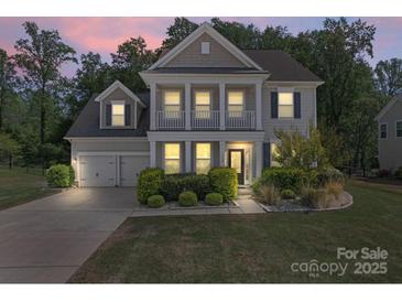 Charming two-story home features a welcoming porch, well-maintained landscaping, and a two-car garage at 112 Serravista St, Mooresville, NC 28117