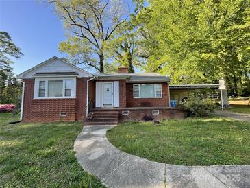 Charming brick home with a walkway leading to the front door, complemented by mature trees and a covered carport at 1218 Forestdale Dr, Salisbury, NC 28144