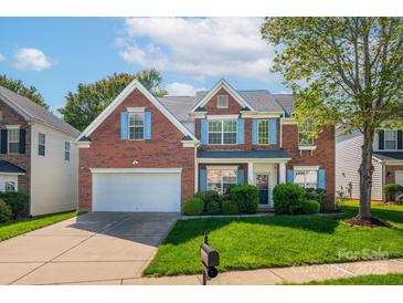 Beautiful brick home with bright blue shutters, a well-manicured lawn, and attached two-car garage at 12404 Mcallister Park Dr, Charlotte, NC 28277