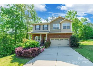 Charming two-story home with a brick facade, a two car garage, and inviting, landscaped front yard at 2202 Chickasaw Loop, Rock Hill, SC 29732