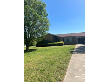 Charming single-story brick home with a well-manicured lawn and mature shade tree at 28344 Canton Rd, Albemarle, NC 28001