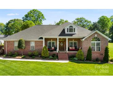 Charming brick home features a manicured lawn, welcoming front porch, and dormer window, creating a picturesque curb appeal at 3003 Eaker Dr, Cherryville, NC 28021