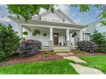 Charming home featuring a welcoming front porch with stone accents and lush landscaping at 365 Delburg St, Davidson, NC 28036