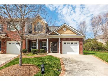 Charming brick townhome with manicured front yard, front-entry two-car garage, and a cozy front porch at 4015 Broadview Ln, Gastonia, NC 28056