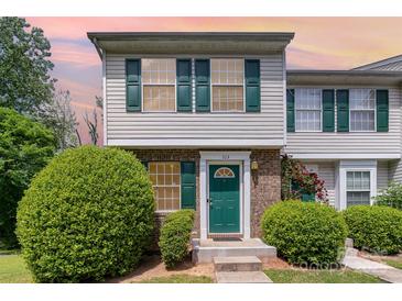 Charming townhome with green door and shutters, complemented by lush landscaping and brick accents at 513 Lex Dr, Charlotte, NC 28262