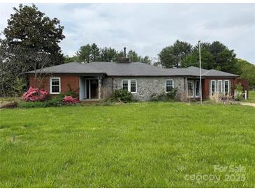 Traditional ranch-style home with a stone facade and brick accents, complemented by a green lawn at 6482 Taylorsville E Hwy, Hiddenite, NC 28636