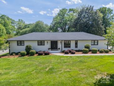 Charming one-story home with manicured lawn, inviting entry, and black framed windows at 8330 Fallsdale Dr, Charlotte, NC 28214