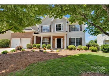 Charming two-story home featuring a brick and siding facade with a well-manicured lawn and inviting landscaping at 105 Runningdeer Dr, Mooresville, NC 28117