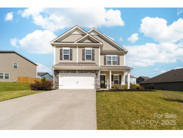 Charming two-story home with a two car garage, a well-manicured lawn, and a cozy front porch at 132 Moores Branch Rd, Mount Holly, NC 28120