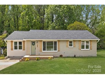 Charming single-story home with a well-manicured lawn and neutral-toned brick and vinyl siding at 145 Burton Hills Cir, Gastonia, NC 28054