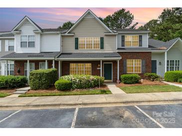 Charming townhome features a brick facade, lush landscaping, and convenient parking at 1720 Forest Side Ln, Charlotte, NC 28213