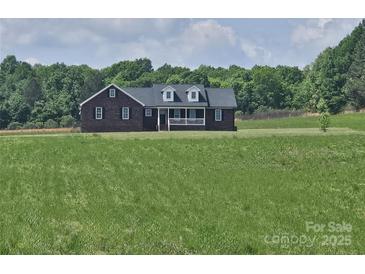 Inviting single-Gathering home boasting a brick facade and covered front porch, nestled on a spacious lot at 485 Hilltop Rd, Oakboro, NC 28129