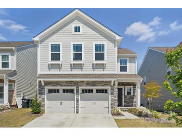 Charming two-story home featuring a stone facade, attached two-car garage, and well-maintained landscaping at 637 Scotch Meadows Loop, Monroe, NC 28110