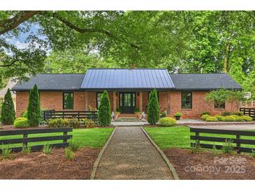 Charming brick home with a metal roof and beautifully landscaped front yard at 742 Lansdowne Rd, Charlotte, NC 28270