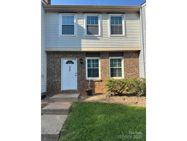 Charming townhouse featuring a brick facade, white door, and well-maintained landscaping at 7539 Holly Grove Ct, Charlotte, NC 28227