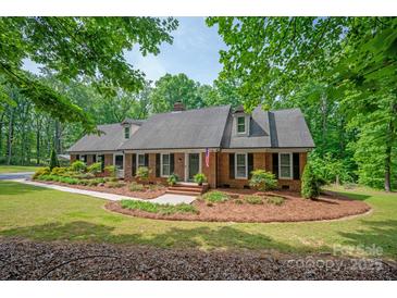 Charming brick home with lush landscaping and mature trees, nestled in a peaceful setting at 9941 Heritage Oak Ln, Waxhaw, NC 28173